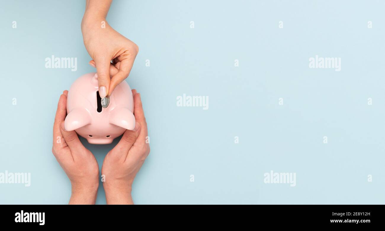 Frau legt eine Münze in ein Sparschwein. Budget, Geld sparen Konzept Stockfoto