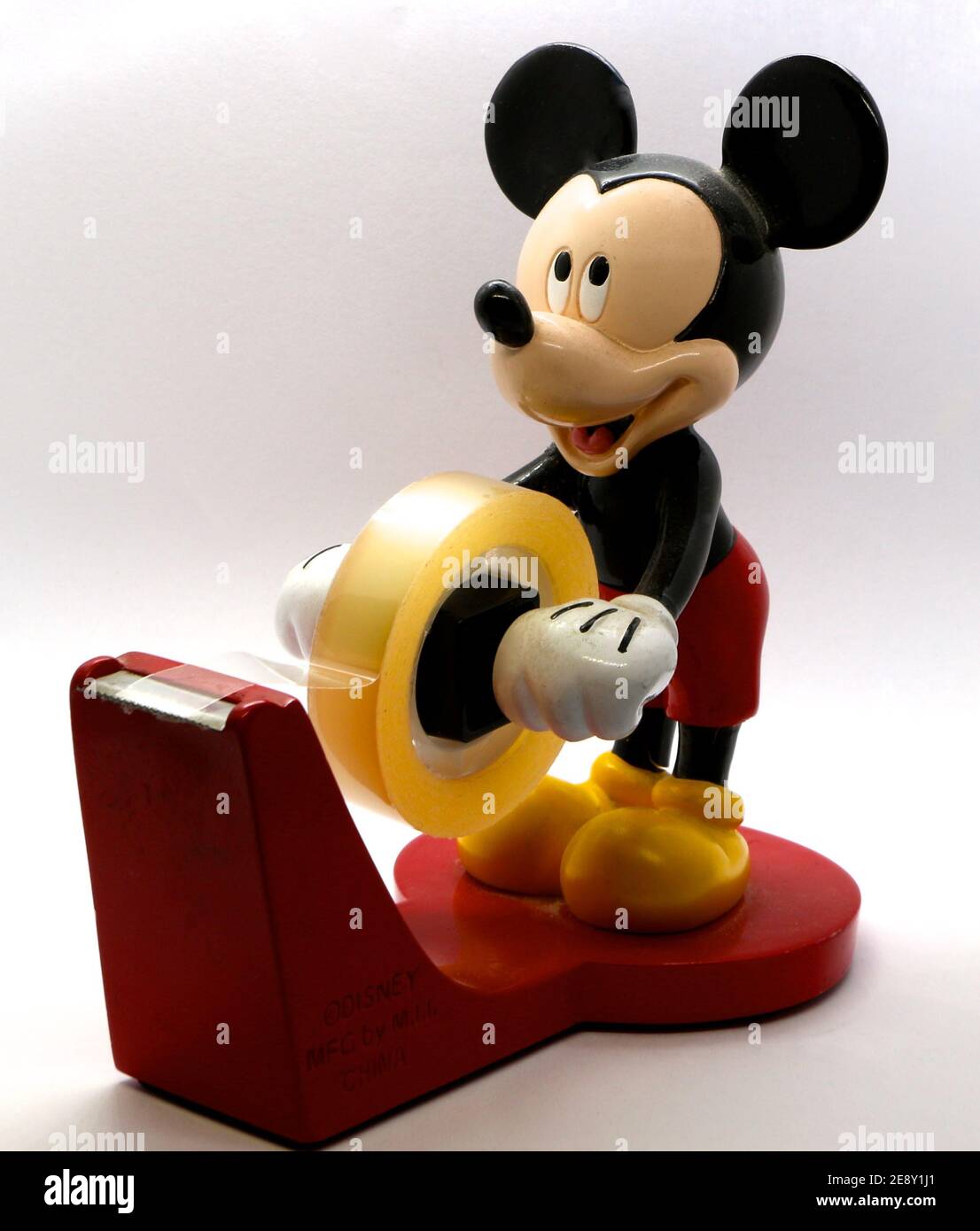 Foto eines Selbstklebespenders von Walt Disney mit einer lächelnden Mickey Mouse, die die Selbstkleberolle hält Stockfoto