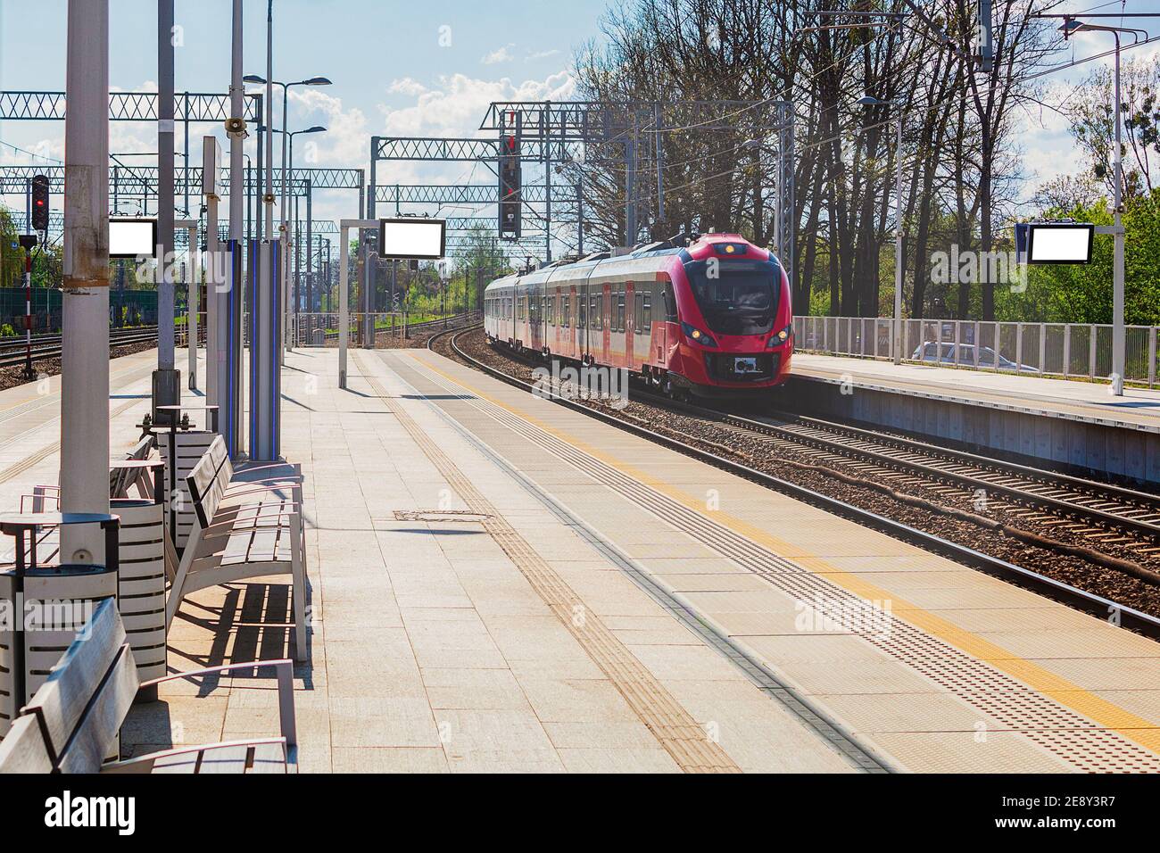 Der Zug kommt am Bahnsteig an. Die Lokomotive des roten Zuges kommt am Bahnsteig an Stockfoto