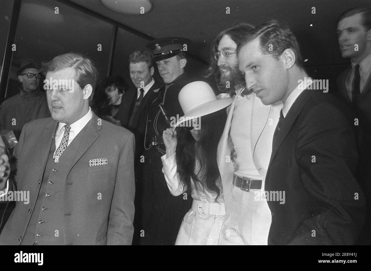 John Lennon und Yoko Ono mit Leibwächtern nach zwei einwöchigen Schlafzimmern für Frieden im Hilton Hotel in Amsterdam, 1969. Stockfoto