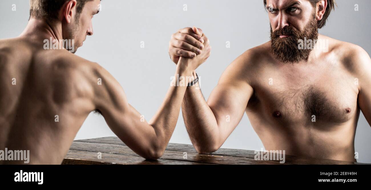 Arme ringen dünne Hand, großer starker Arm im Studio. Zwei Männerhände umklammten Arm Wrestling, stark und schwach, ungleiche Übereinstimmung. Armdrücken. Stark Stockfoto
