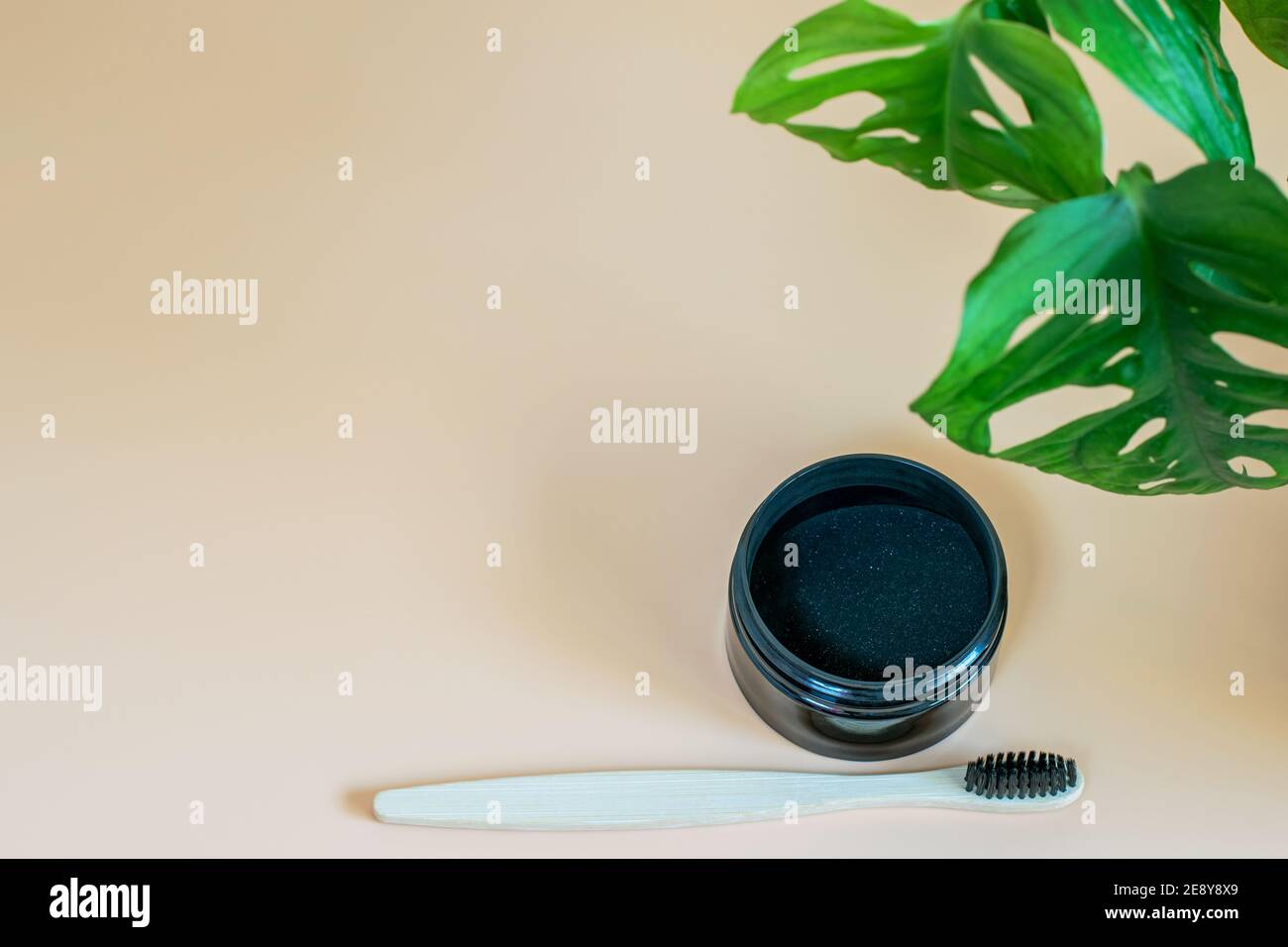Aktivkohle und Bambus Zahnbrste fr Zahnaufhellung auf neutralem beigen  Hintergrund, Monstera Blatt als dekoratives natrliches Element. Gesund  Stockfotografie - Alamy