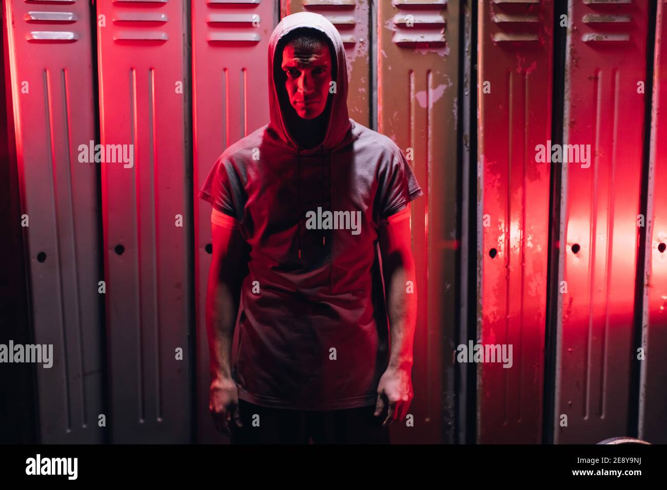 Mann machen Sie sich bereit für das Boxtraining in der Umkleidekabine. Der  Mensch sieht die Kamera im Neonlicht an Stockfotografie - Alamy