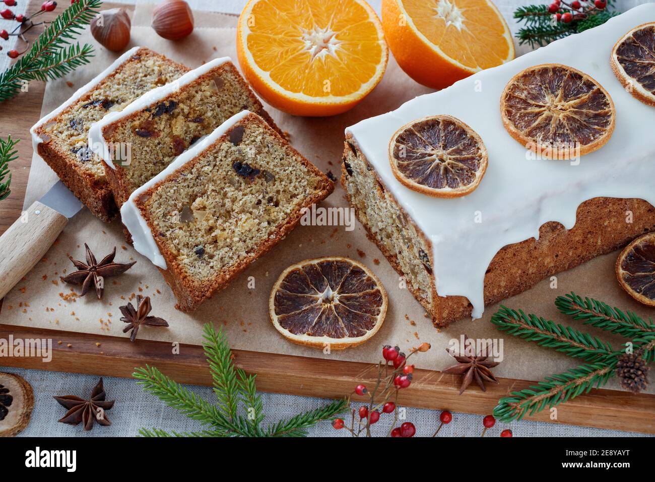 weihnachtskastenkuchen mit orangefarbenem Zuckerguss auf Holzbrett Stockfoto