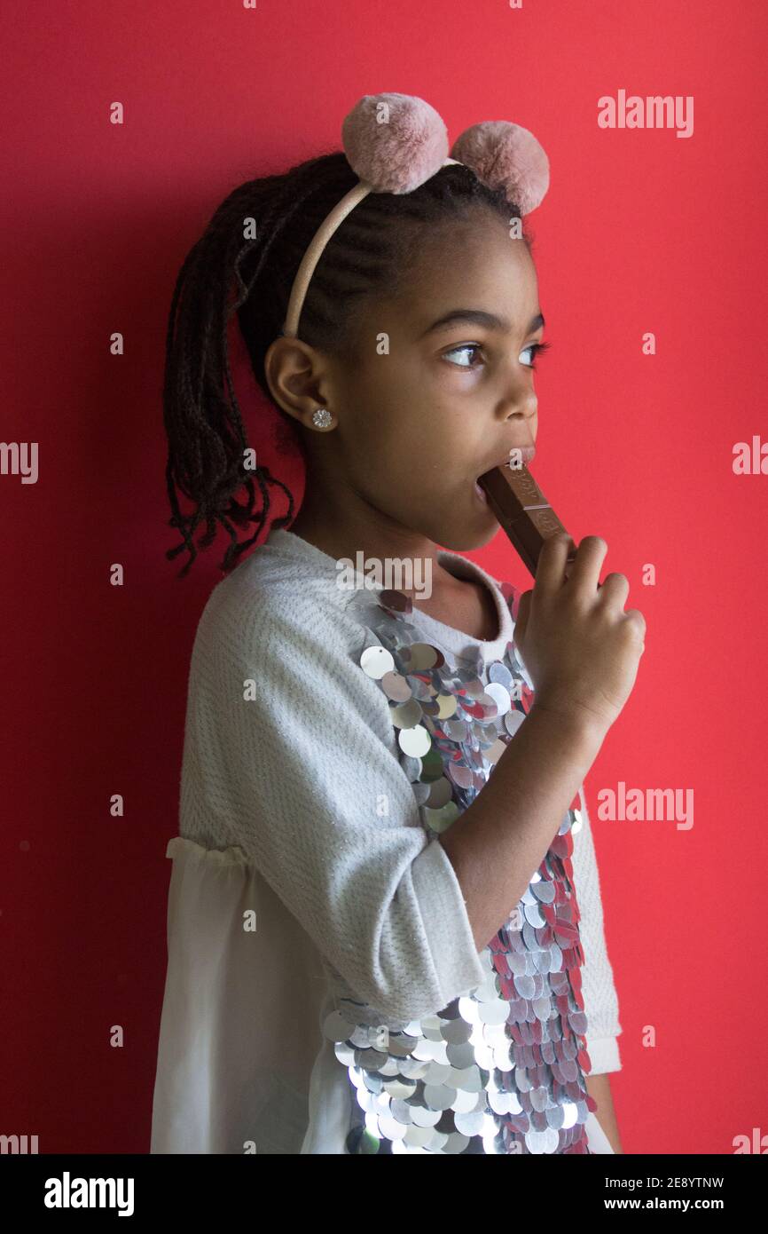 Kleine afro Mädchen essen Schokolade Stockfoto