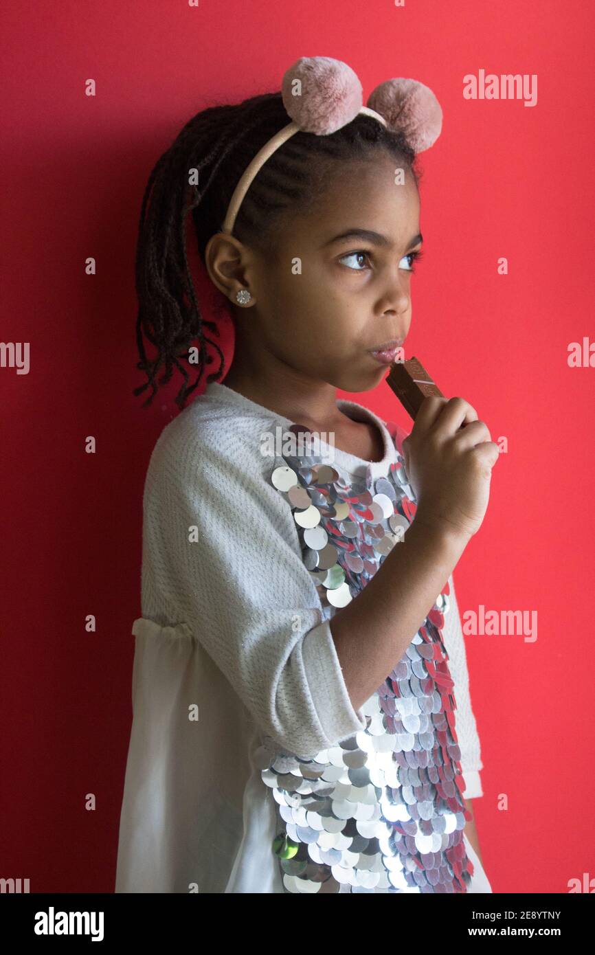 Kleine afro Mädchen essen Schokolade Stockfoto