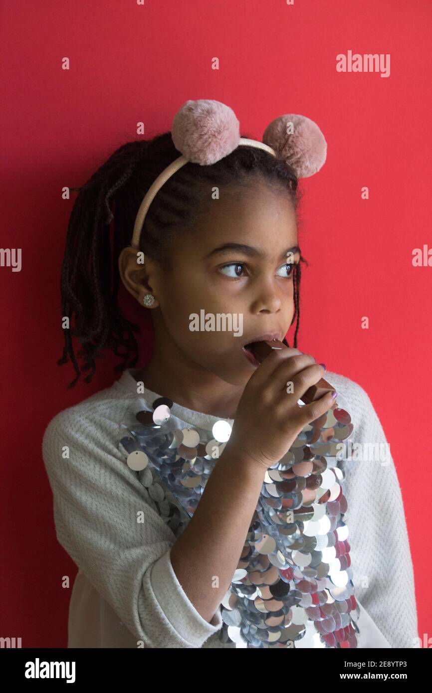 Kleine afro Mädchen essen Schokolade Stockfoto