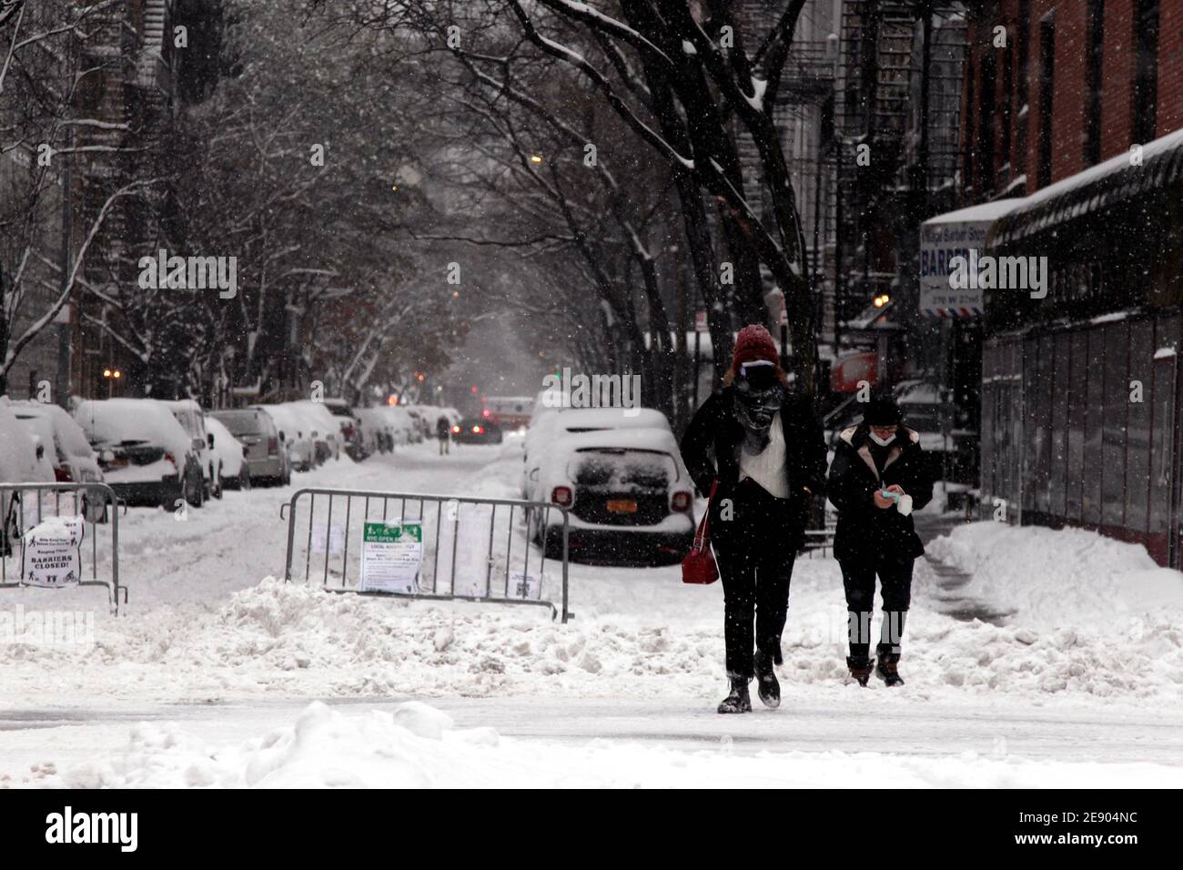 New York City, New York, Usa. Februar 2021. Fußgänger navigieren auf einer rutschigen Straße, wenn am Montag Schnee auf dem Chelsea-Teil von Manhattan fällt, während ein großer Schneesturm die Gegend von New York City heute überflutete. Es wird vorhergesagt, dass die Stadt bis zu zwei Fuß Schnee bekommen könnte, bevor der Sturm nachlässt.Quelle: Adam Stoltman/Alamy Live News Stockfoto