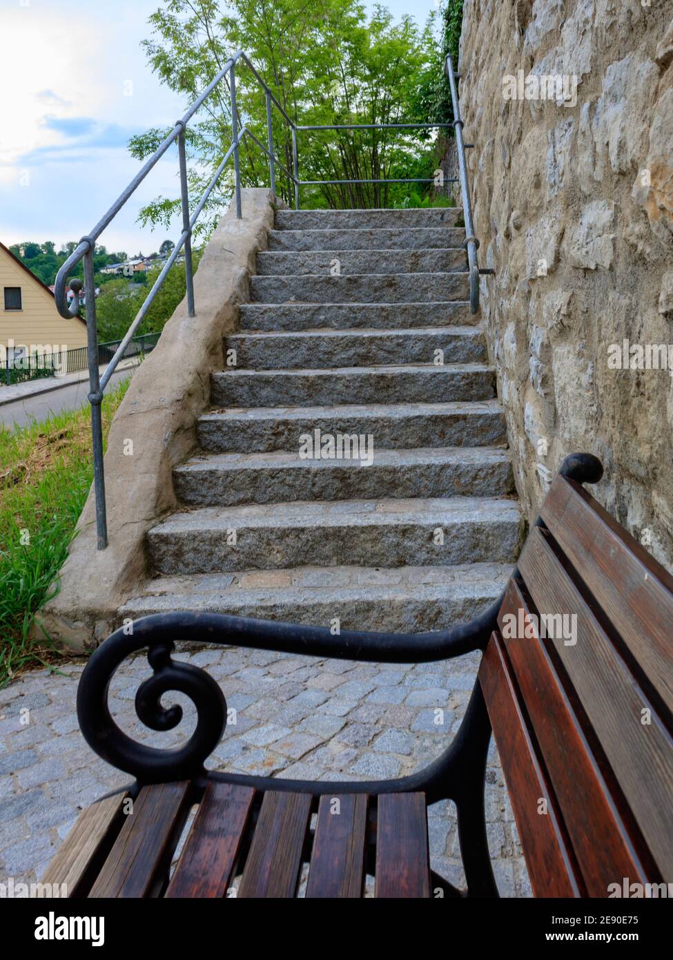 Vertikale Aufnahme einer alten Treppe und einer Holzbank in einem kleinen Dorf Neudenau, Deutschland Stockfoto