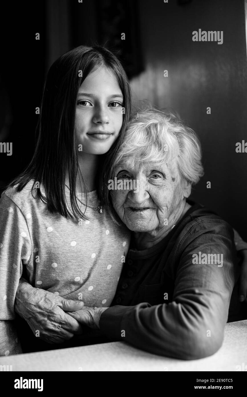 Porträt des kleinen Mädchens und ihrer alten Urgroßmutter. Schwarzweiß-Foto. Stockfoto
