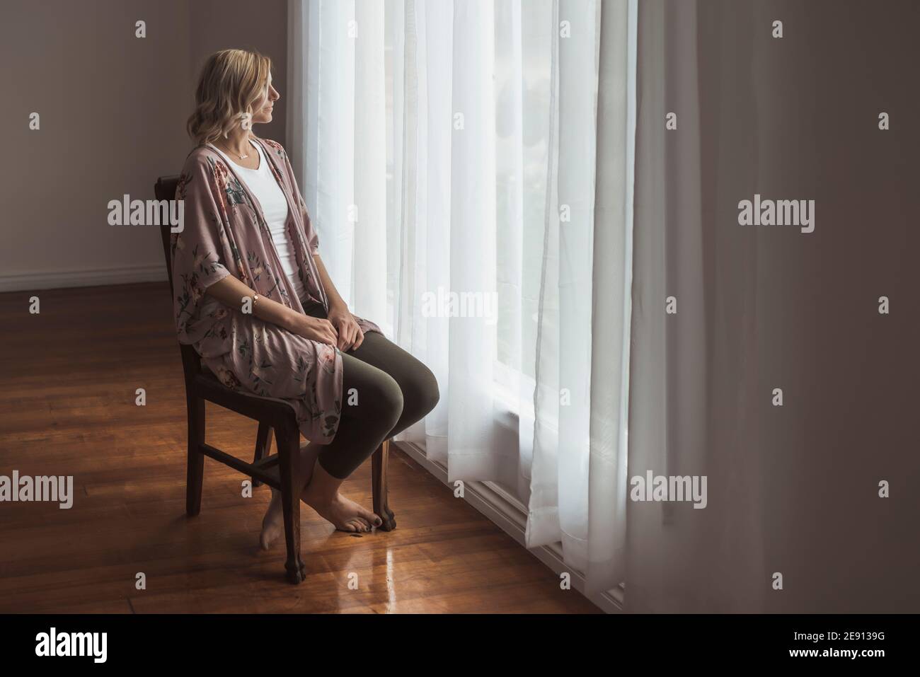 Portrait der schönen Mutter im Studio Blick aus dem Fenster Stockfoto
