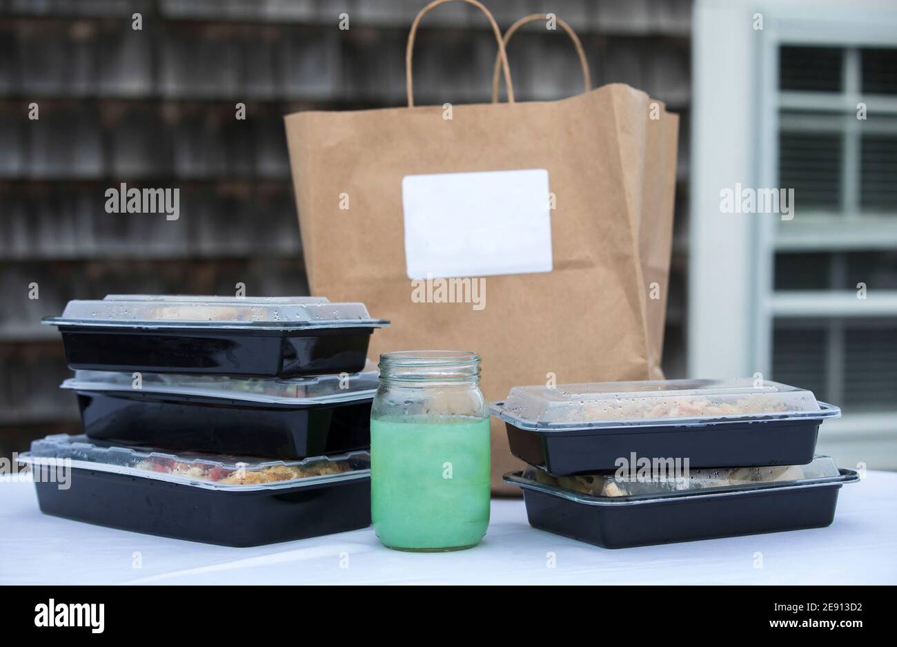 Takeout-Boxen mit braunem Papierbeutel und To-Go aufgestapelt Margarita Getränk Stockfoto