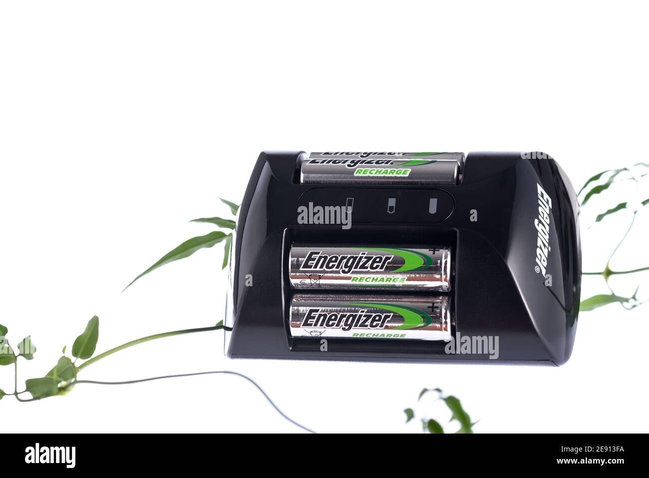 Boise, ID, 22. Januar 2021. Energizer Akkuladegerät mit vier AA-Batterien auf weißem Hintergrund mit grüner Weinrebe umwickelt. Stockfoto