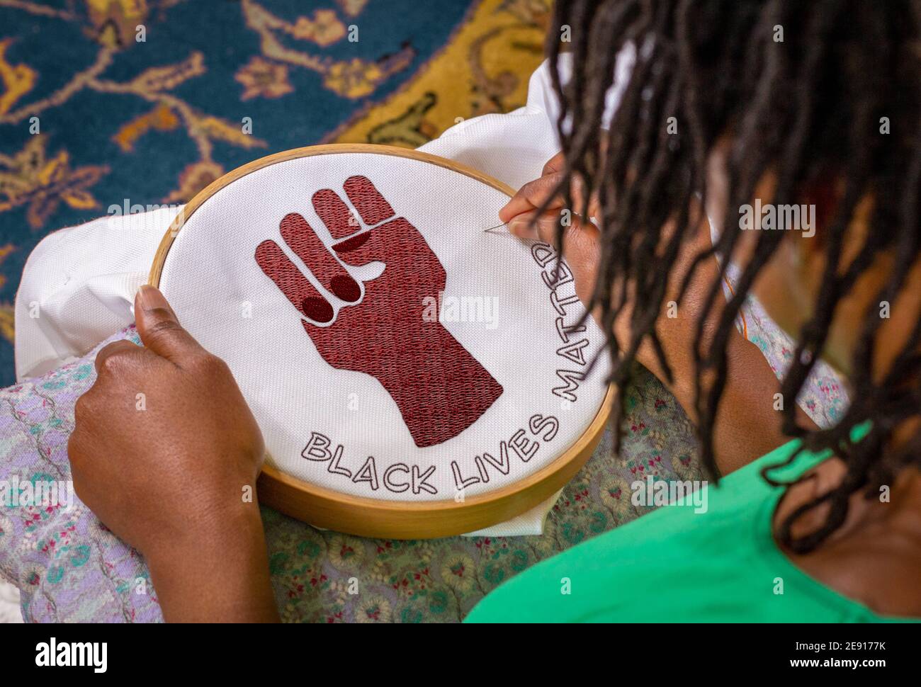 Bastelaktivismus, Frau näht schwarze Leben Materie Stickerei auf Reifen, Kunst Craftivismus Aktivismus. Stockfoto