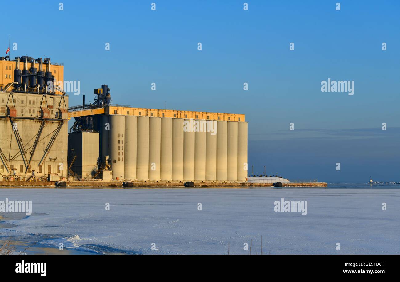 Ein Getreideaufzug an einem sonnigen Tag steht am eisgefüllten Hafen von Lake Superior in Thunder Bay, Ontario, Kanada. Stockfoto