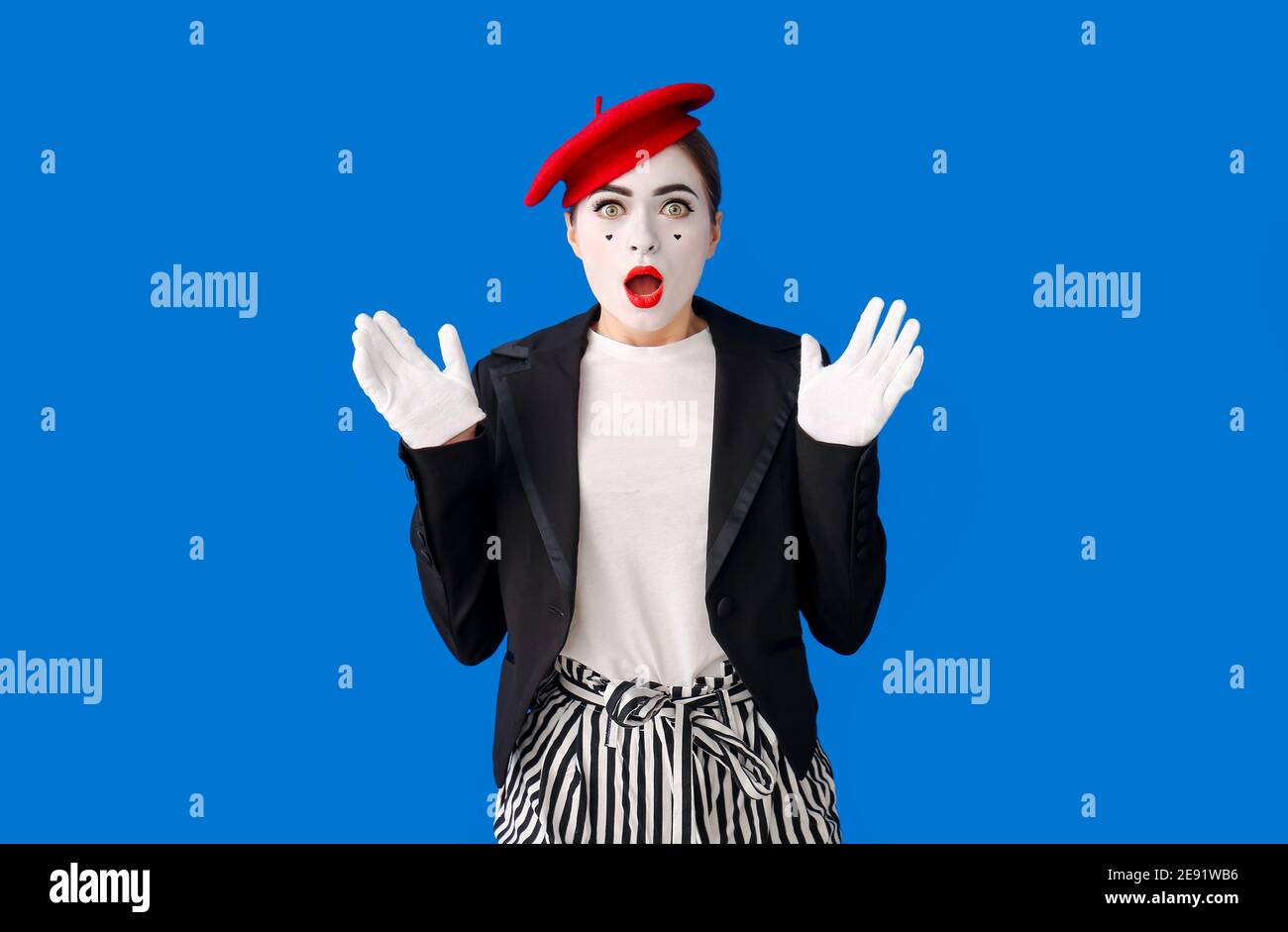 Schockierte weibliche Pantomimist auf farbigem Hintergrund Stockfoto