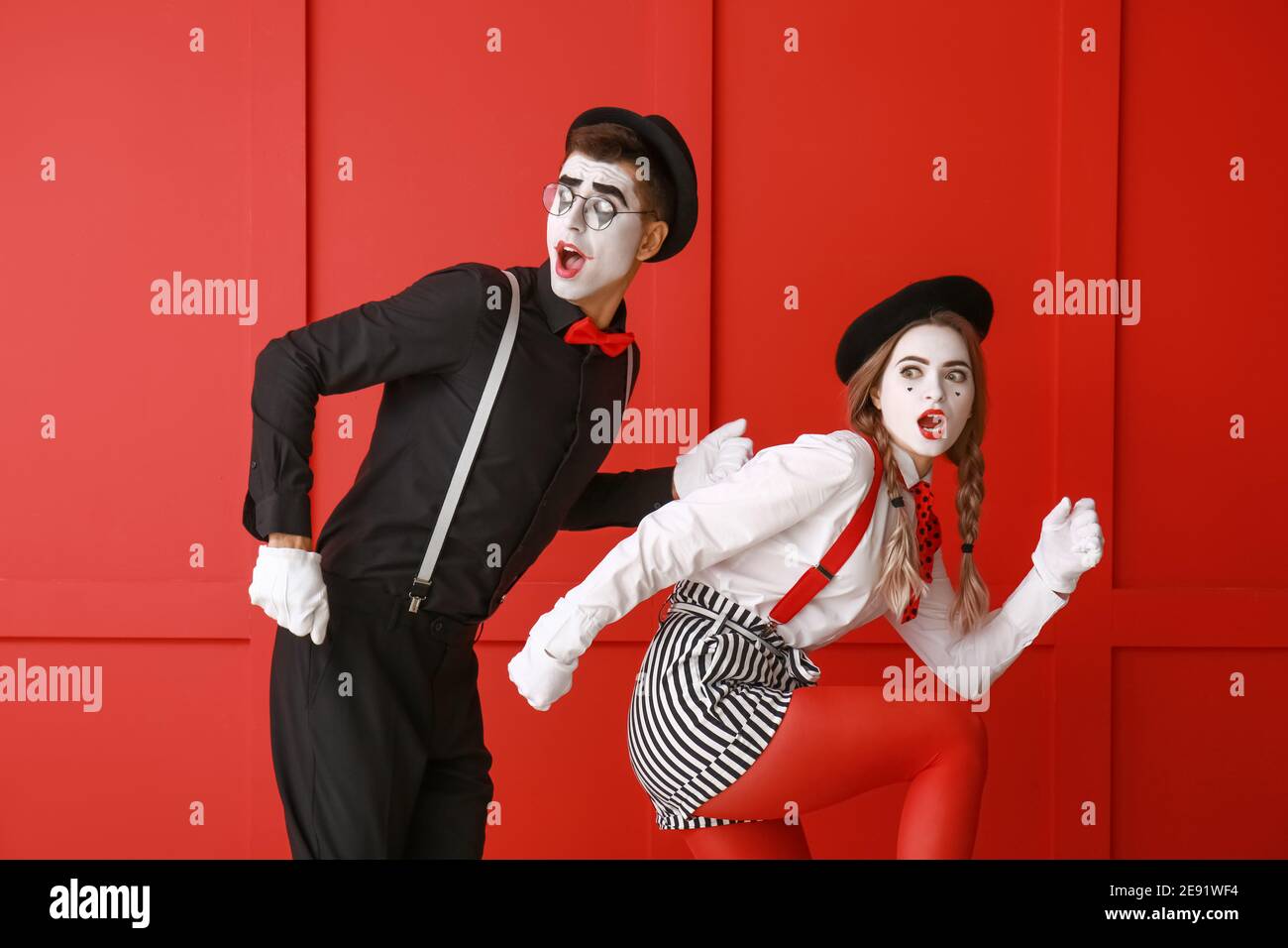 Männliche und weibliche Pantomimisten auf farbigem Hintergrund Stockfoto