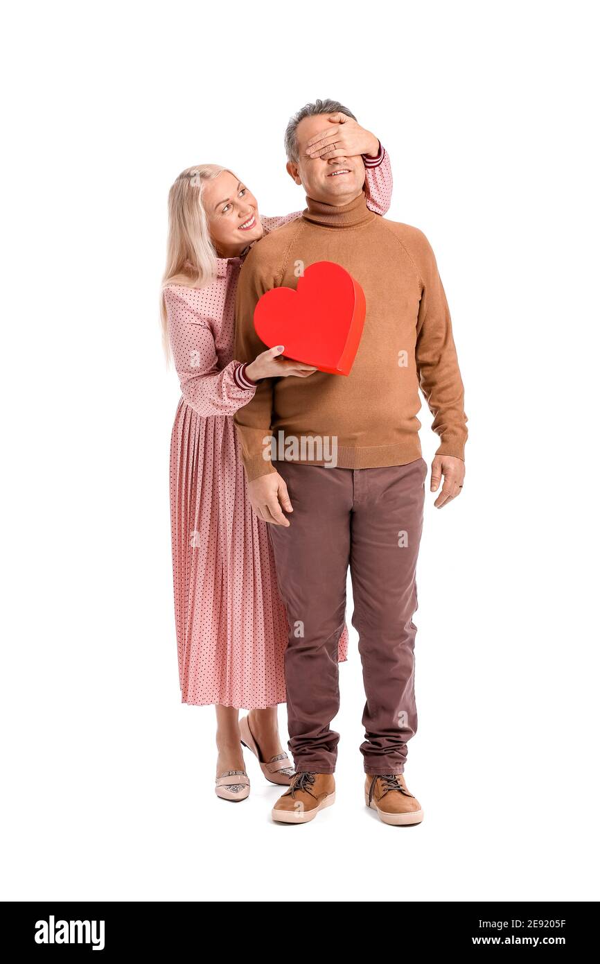 Reifes Paar mit Geschenk auf weißem Hintergrund. Valentinstag-Feier Stockfoto