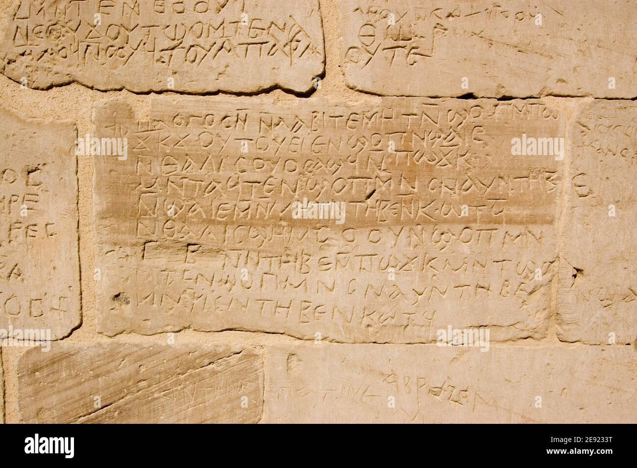 Alte griechische Schrift in die Wand eines alten ägyptischen Tempels in Deir el Medina, Luxor, Ägypten geschnitzt. Stockfoto