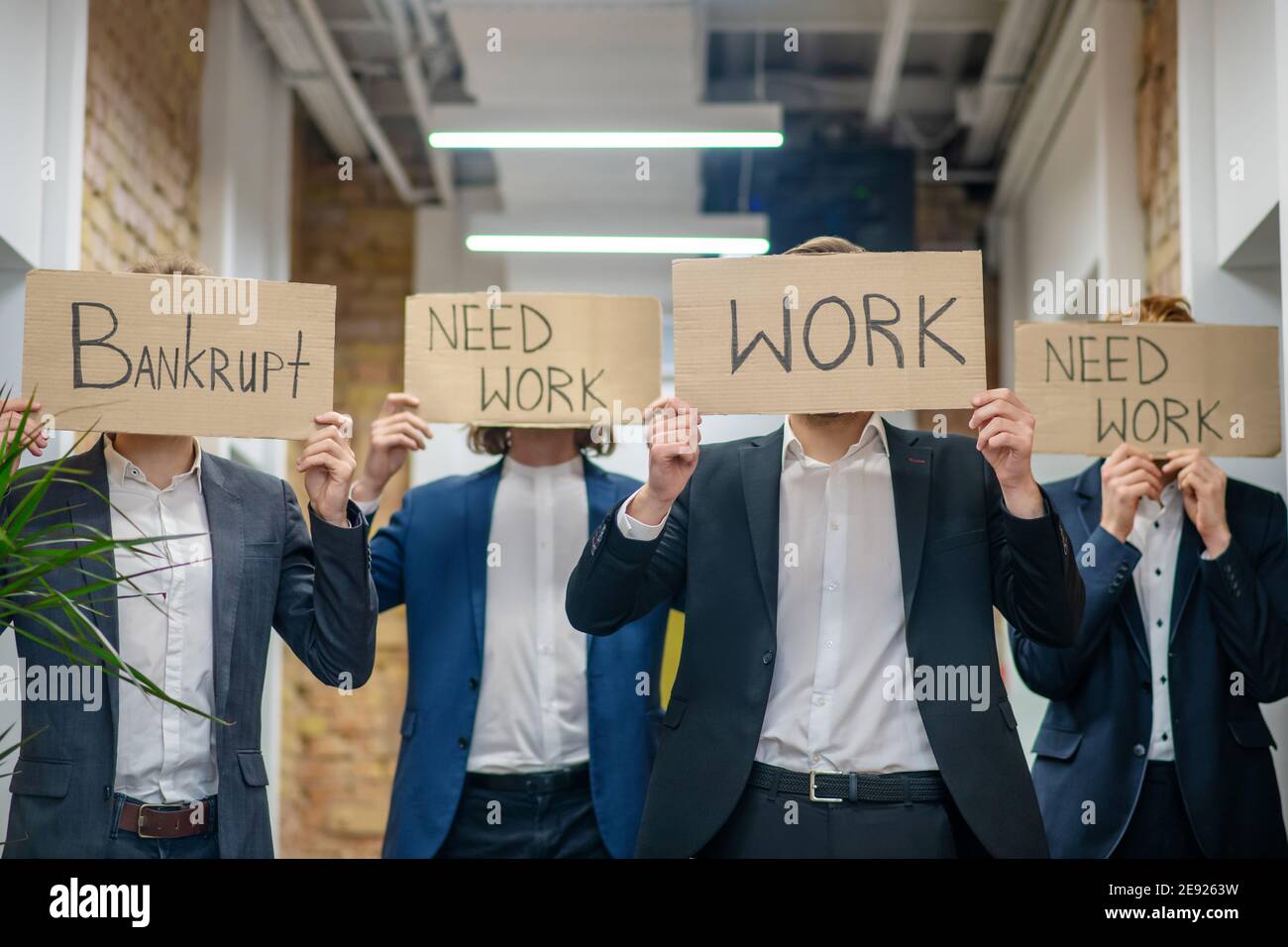 Männer mit Plakaten fordern Arbeit im Innenbereich Stockfoto