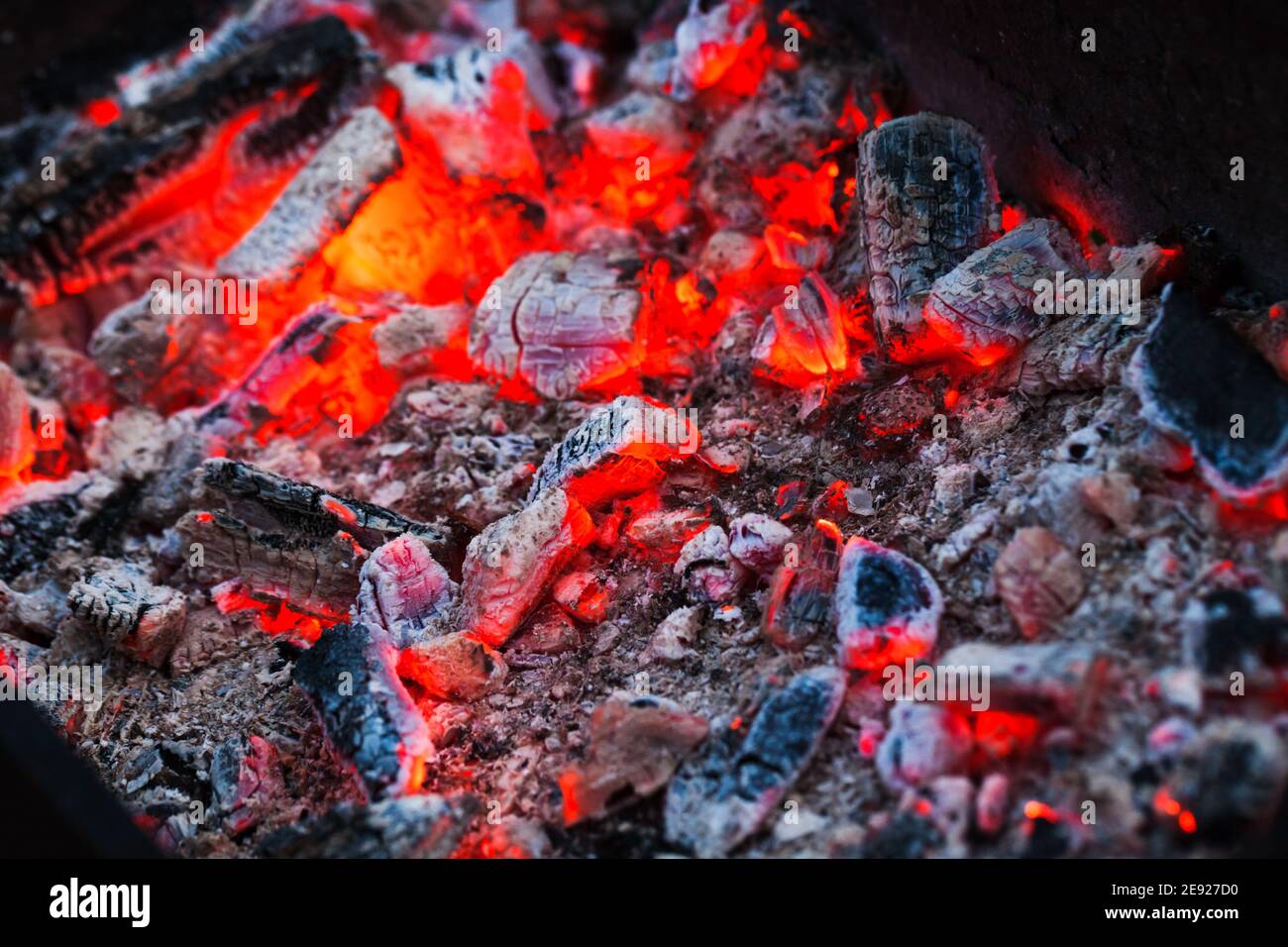Leuchtend rote brennende Kohlen, abstraktes Hintergrundfoto Stockfoto