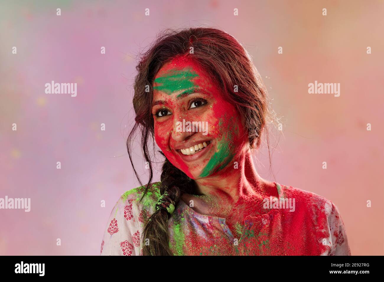 Porträt einer Frau, die holi mit Farben auf ihr feiert Gesicht Stockfoto