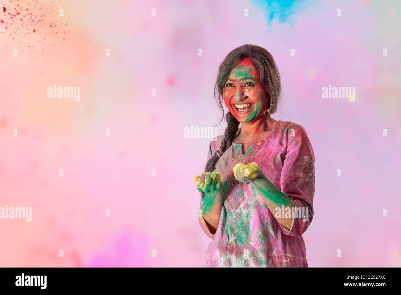 Schöne Frau mit Farben in den Händen und gulal auf Ihr Gesicht lächelt auf Holi Stockfoto