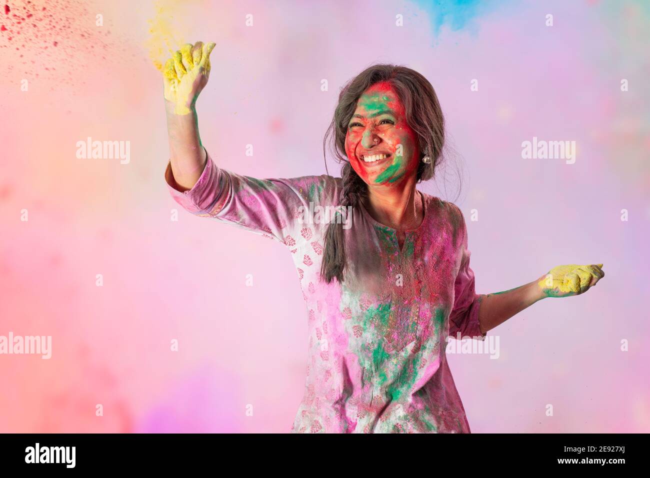 Junge Frau spielt mit Gulal anlässlich Holi Stockfoto