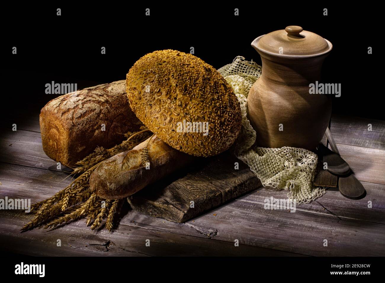 Verschiedene Brotsorten und Keramikvase auf einem Atelier Hintergrund Stockfoto