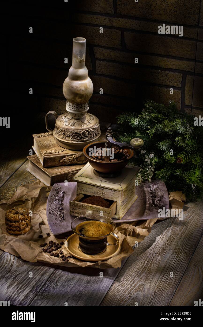 Alte Öl handgemachte Lampe, Kaffeemühle und Tasse Kaffee auf einem Studio Holzhintergrund Stockfoto