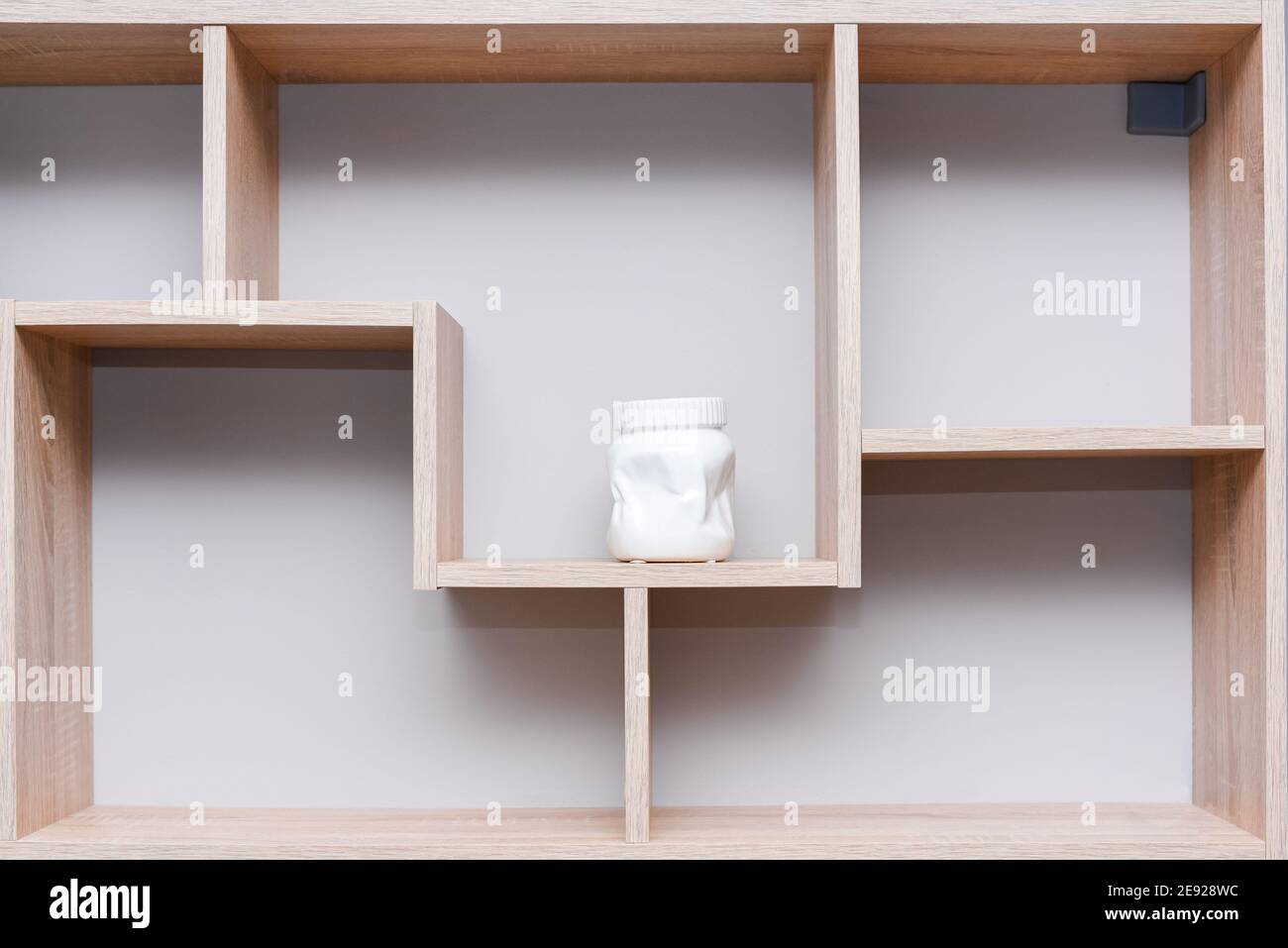 Wandregal aus Holz mit weißer Keramikvase. Home Design Komposition im minimalistischen Stil. Stockfoto