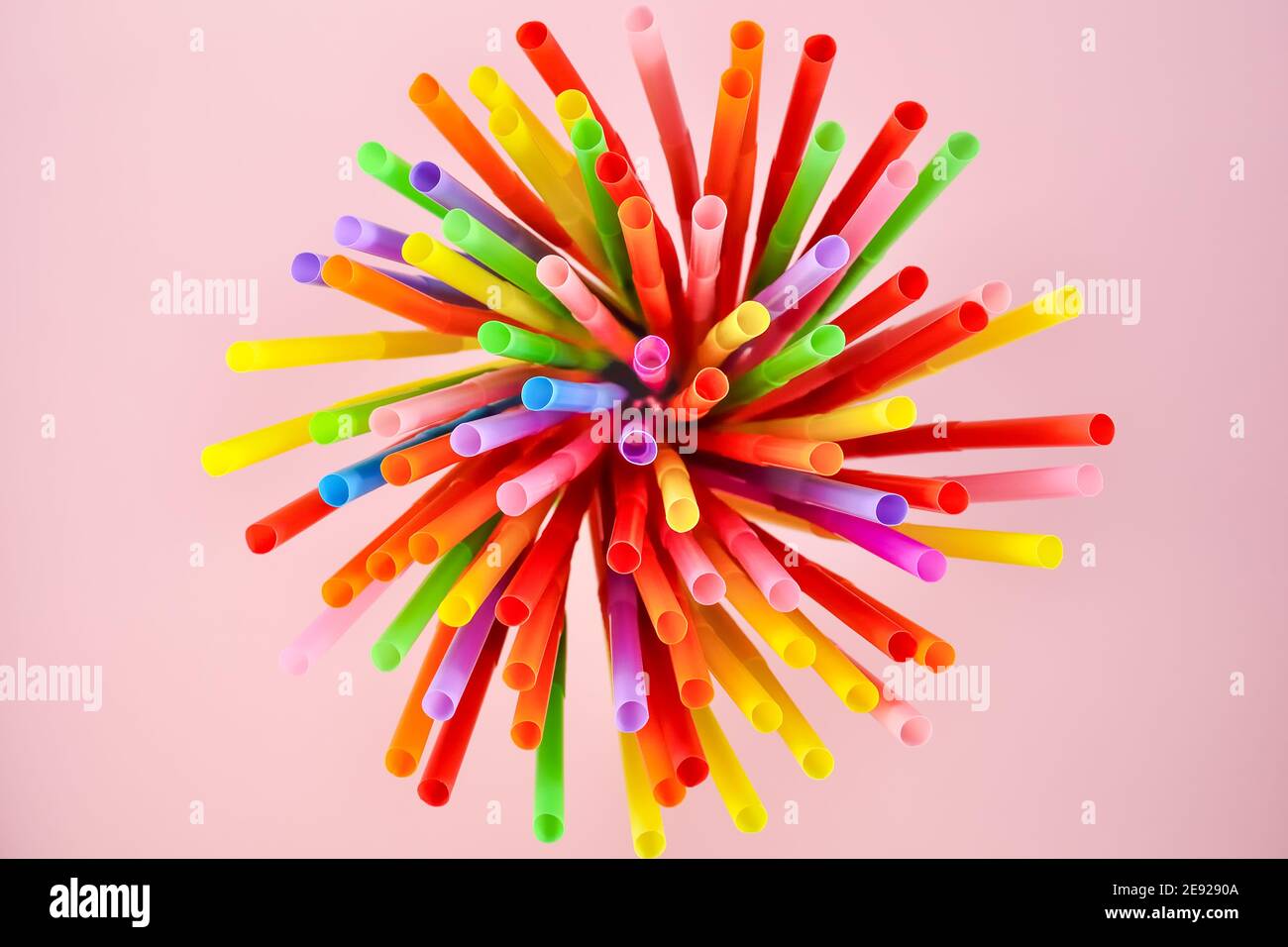 Draufsicht auf bunte Cocktail-Plastikstrohhalme auf rosa Hintergrund. Stockfoto