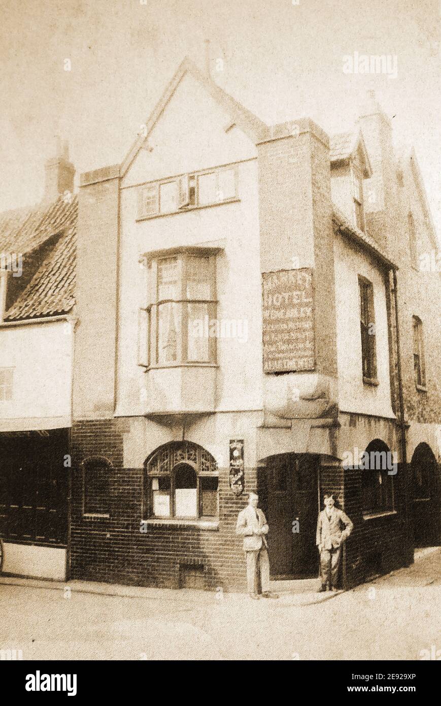 Das ehemalige Market Hotel im Market Place um 1925 am Ende von Sandgate, Whitby, North Yorkshire, einer der vielen Whitby Pubs, die aus der Stadt verschwunden sind. Es war früher bekannt als der Vogel in der Hand und umgangssprachlich knonw als einfach der Markt. Eine sehr dunkle Kneipe mit vielen Fächern, die 1904 fast geschlossen wurde, weil sie innen 'aufgeschlagen' wurde und kein Urinal hatte. Der Vermieter außerhalb der Kneipe abgebildet sein kann Walter Brearly, war dort von 1923-c1932. In seinen letzten Tagen hatte das beliebte Pub seine Wände mit Royal Navy Matrosen Kappen gespendet von lokalen & Besuch Segler gesäumt. Stockfoto