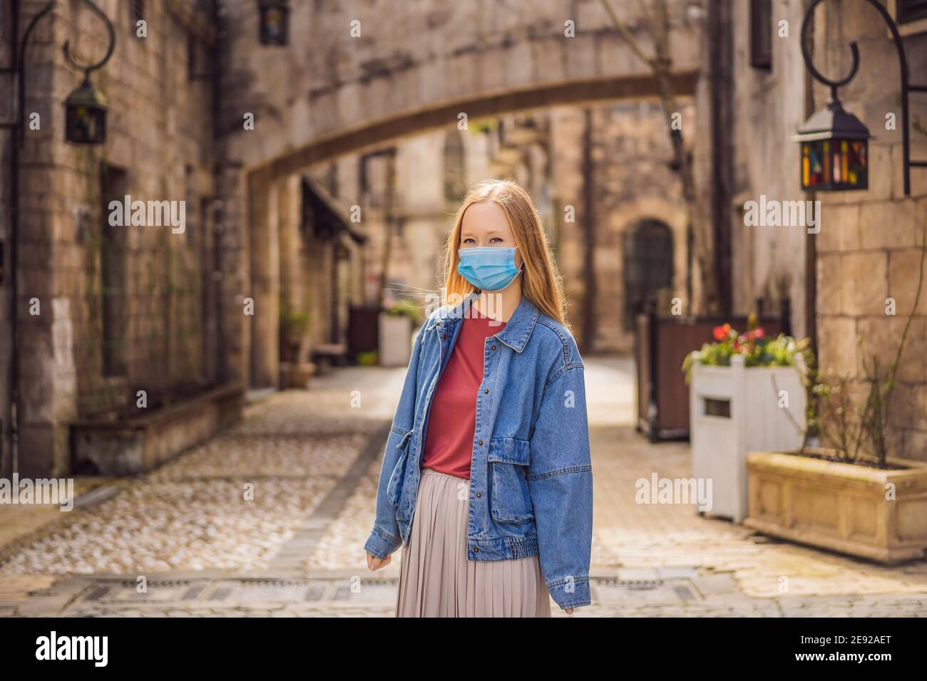 Junge Frau trägt eine medizinische Maske während COVID-19 Coronavirus Tourist Geht die Straße entlang in einer europäischen Stadt nach dem Ende des COVID-19-Coronavirus Stockfoto