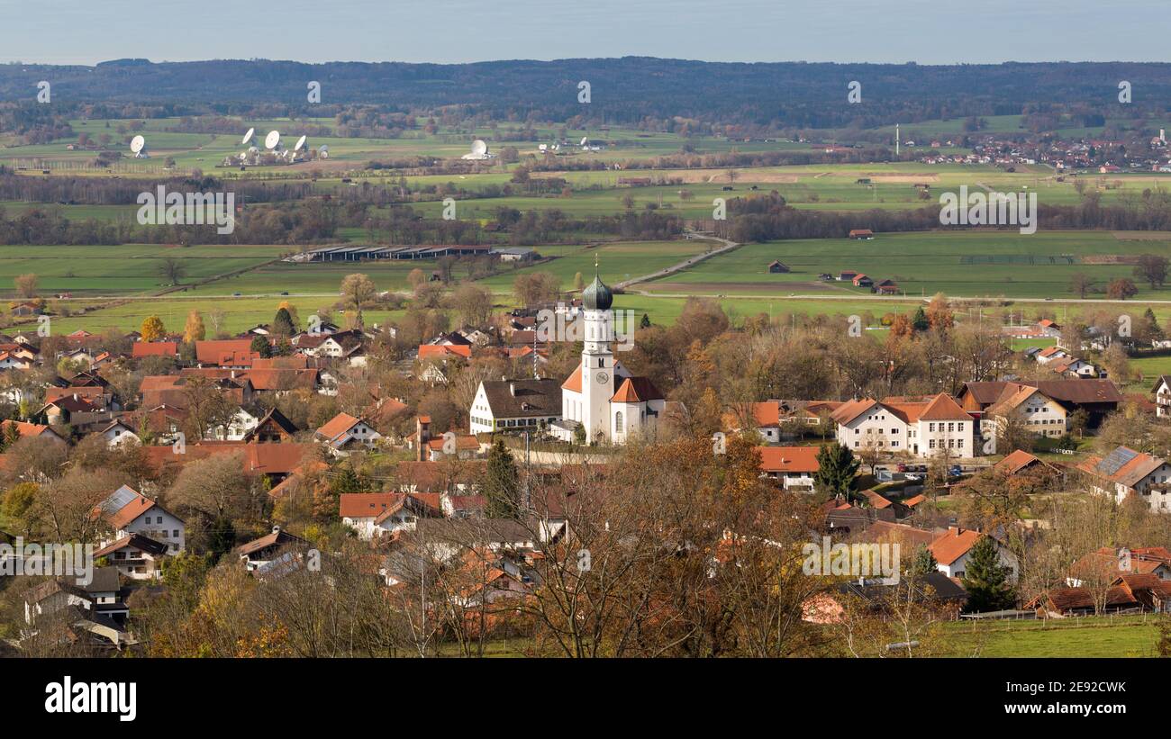 Pähl, Deutschland - 13. Nov 2020: Blick auf die Stadt Pähl mit der Kirche St. Laurentius. Im Hintergrund die Satellitenschüsseln von Raisting. Stockfoto