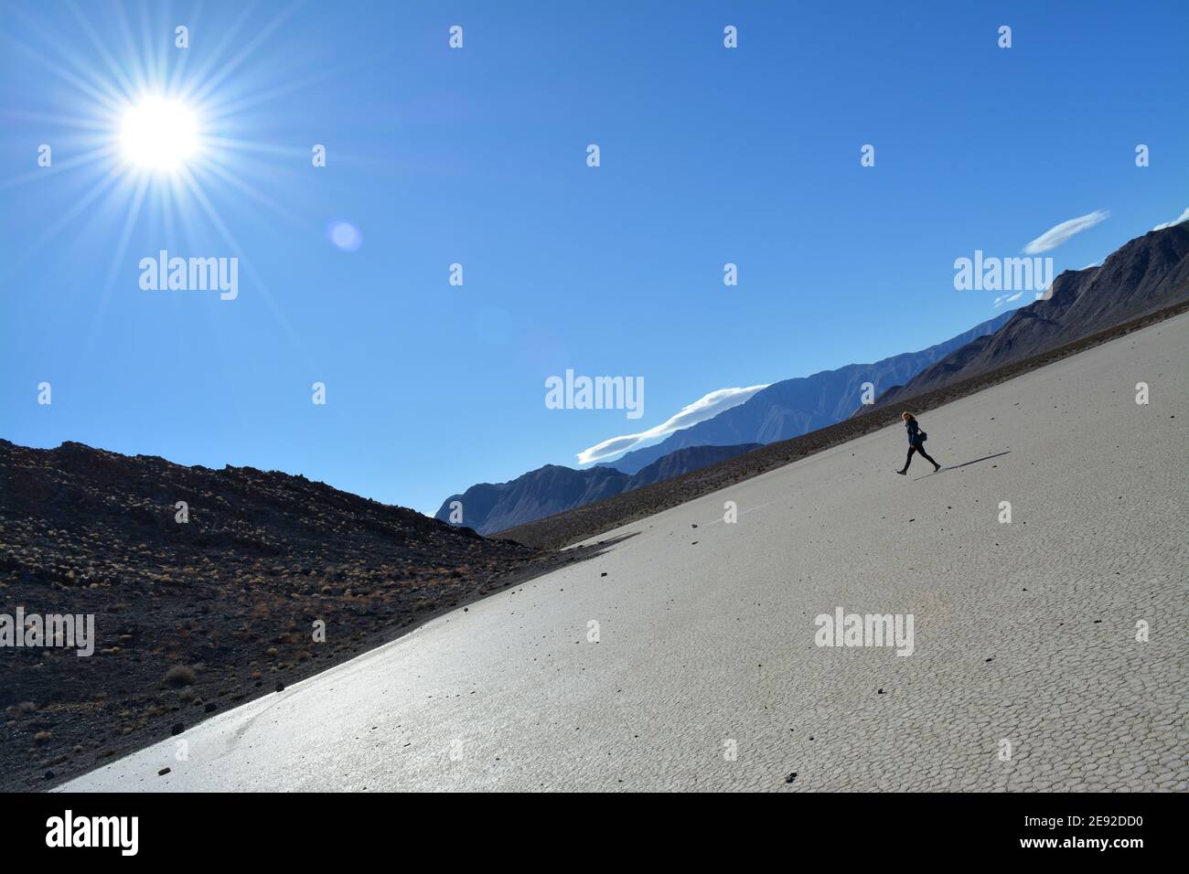Frau, die an einem kalten Dezembertag über die Rennstrecke Playa im Death Valley National Park spazierengeht, wunderschöne Landschaft mit sich bewegenden Felsen, die Spuren hinterlassen Stockfoto