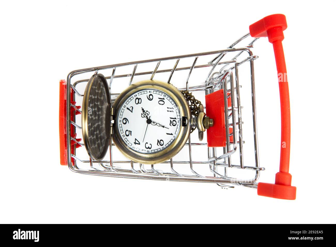 Draufsicht auf eine Vintage-Taschenuhr in einem Mini-Einkaufswagen. Einkaufszeitkonzept. Stockfoto