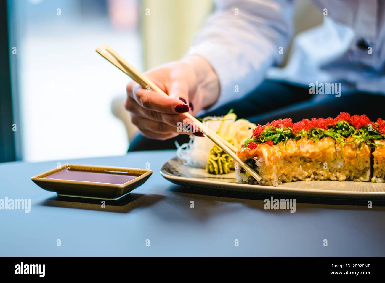 Frau, die Sushi in einem Restaurant isst Stockfoto