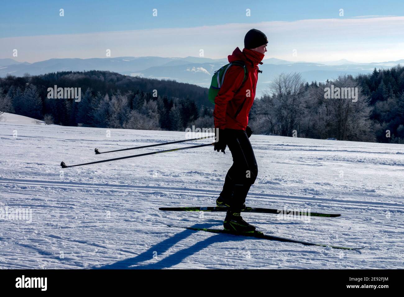 Man Skilanglauf auf einem Bergrücken mit Blick auf einen sonnigen Schnee Landschaft Berge Tschechische Republik Stockfoto