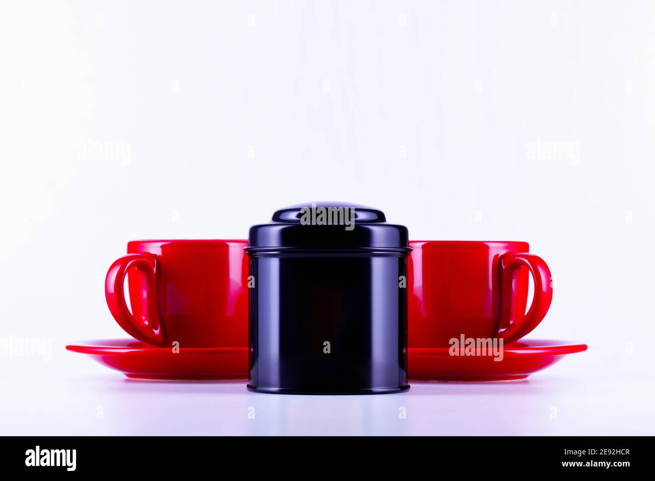 Zwei rote Tassen Tee und schwarze Box auf dem Tee auf dem weißen Hintergrund. Stockfoto