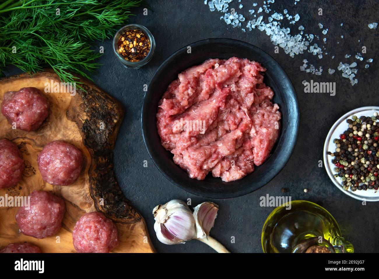 Hausgemachtes Hackfleisch in einer schwarzen Schüssel mit Zutaten. Frisch Raw Hackfleisch zum Kochen Fleischbällchen. Draufsicht. Stockfoto