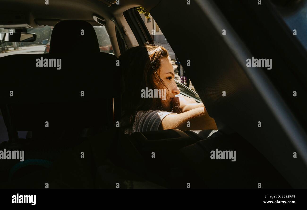 Pre-pubertär Mädchen aus dem Fenster schauen, während in elektrischen sitzen Auto während des Urlaubs Stockfoto