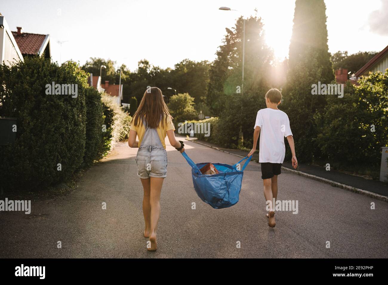Bruder und Schwester tragen Tasche auf der Straße Stockfoto