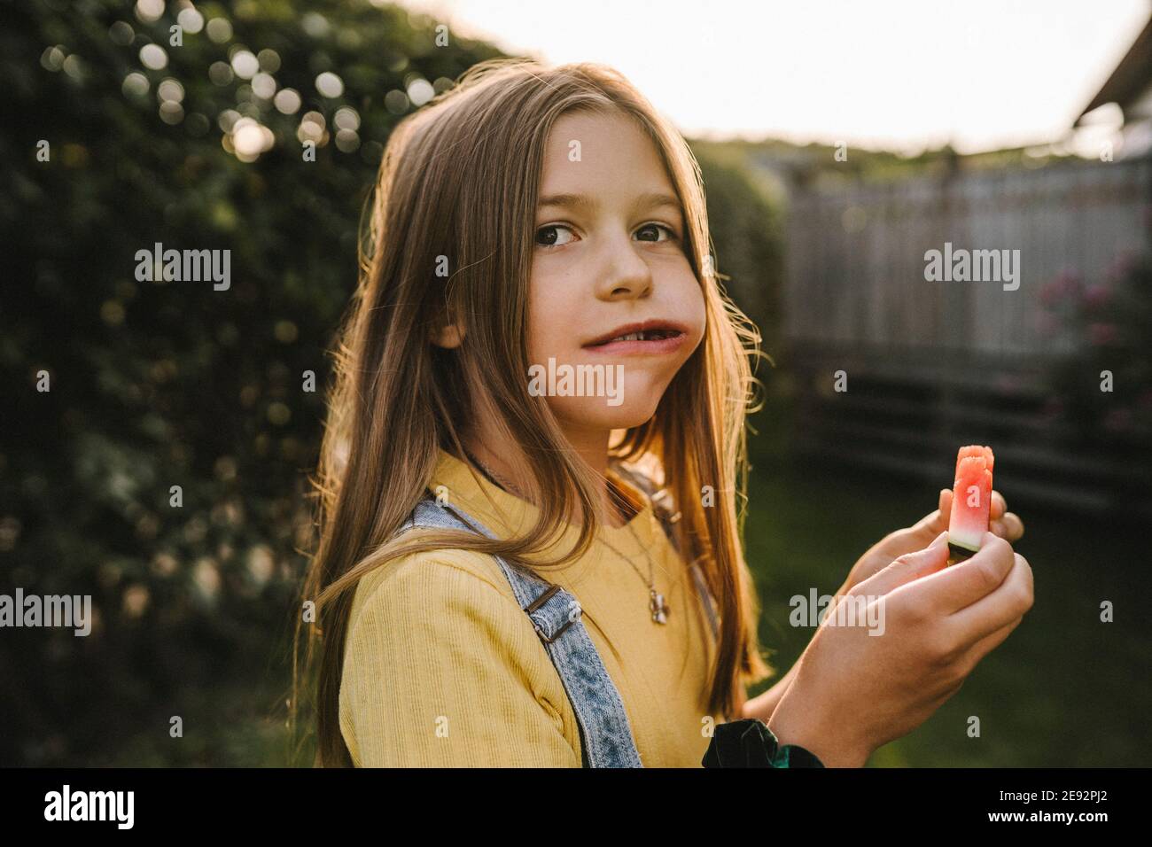 Pre-pubertär Mädchen weg beim Essen Wassermelone im Hinterhof Stockfoto
