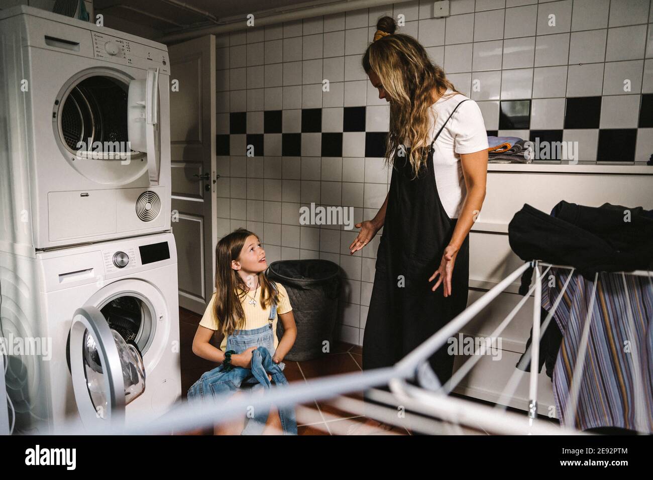 Mutter und Tochter machen Wäsche im Hauswirtschaftsraum Stockfoto