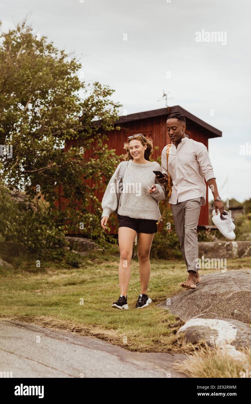 Glückliche Freunde, die gemeinsam gegen den Himmel laufen Stockfoto