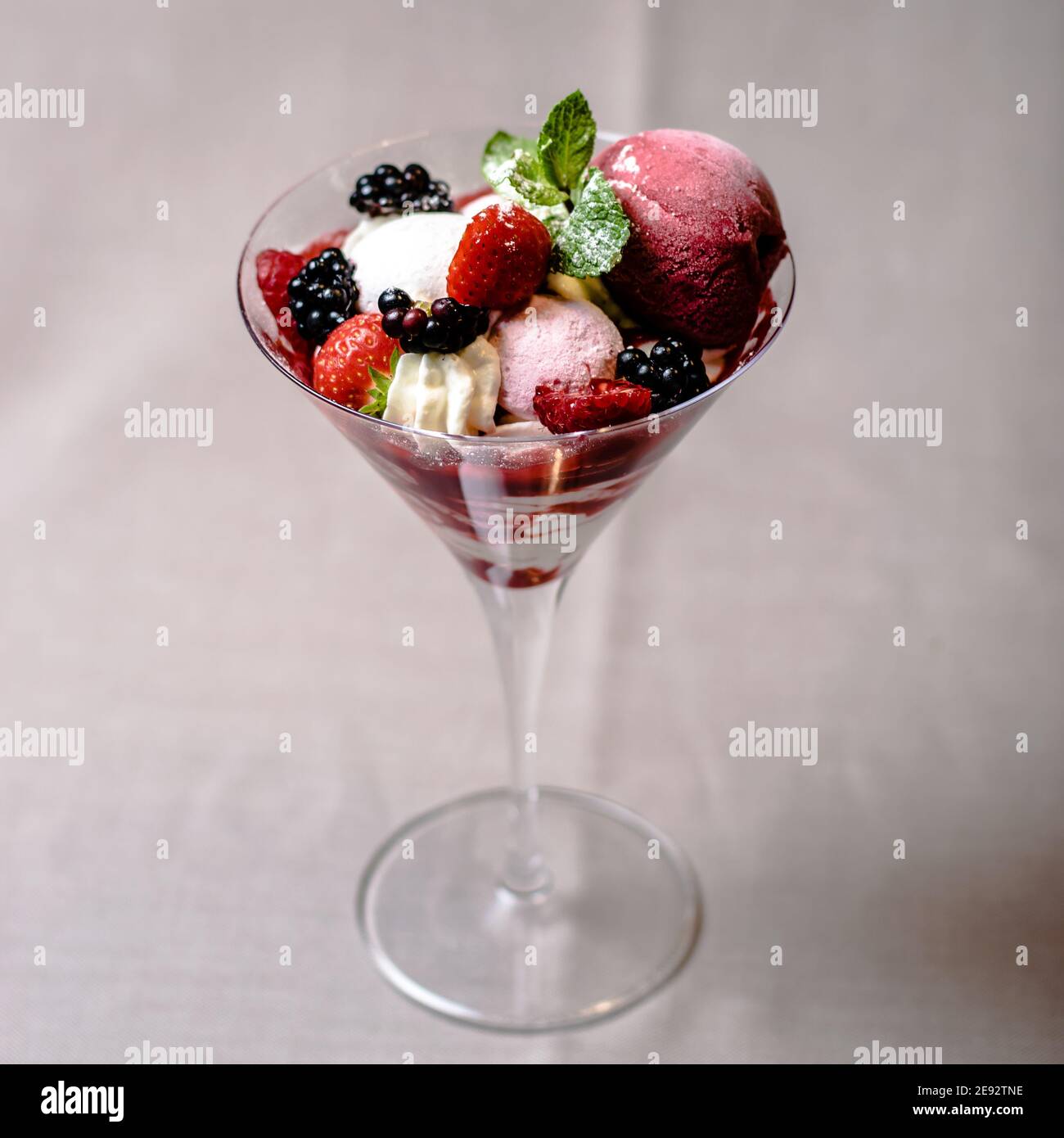 Eis servieren in einem Glas mit verschiedenen Beeren Stockfoto