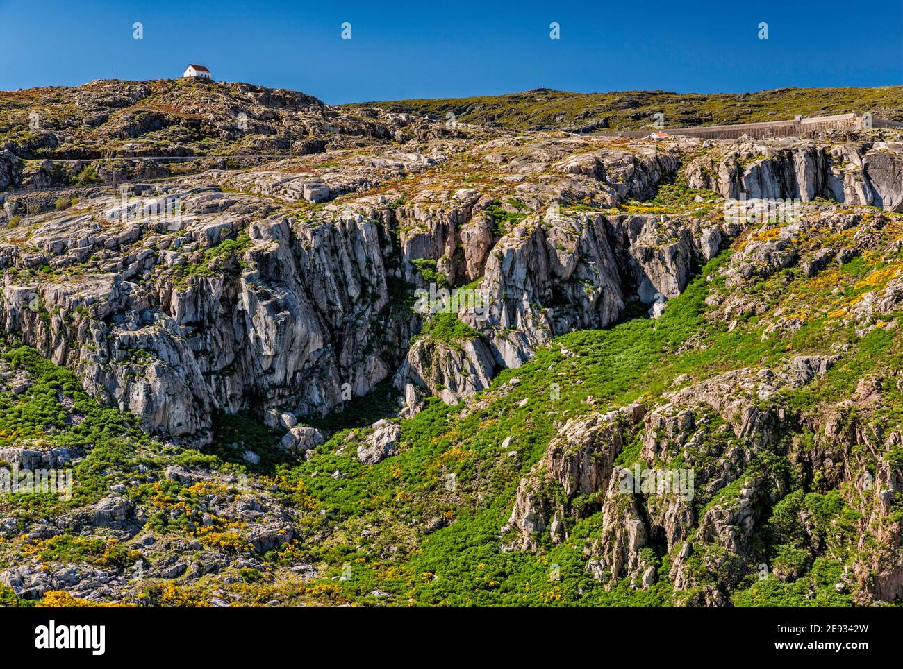 gletscherriegel, Granitfelsen, die durch Gletschererosion exponiert sind, über dem Stausee Covao do Corral, Hütte in der Ferne, Naturpark Serra da Estrela, Portugal Stockfoto