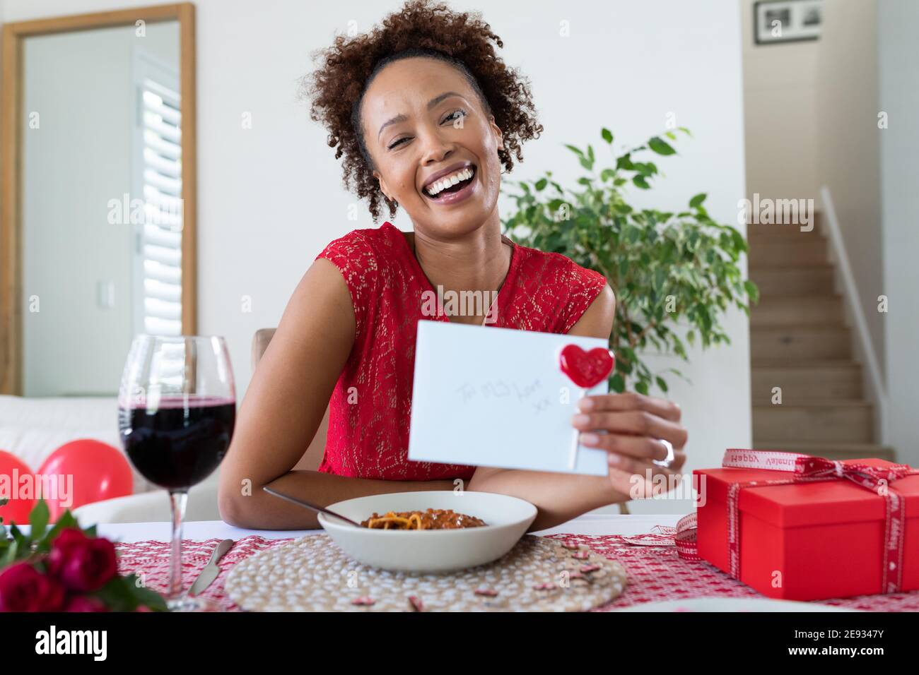 Porträt einer afroamerikanischen Frau mit valentinskarte Videoclip zu Hause Stockfoto