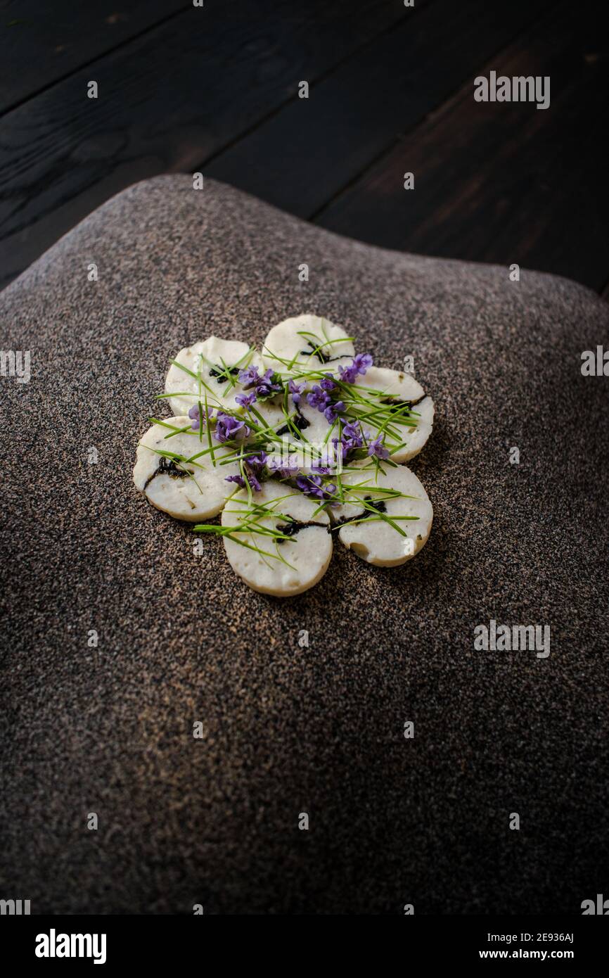 Fischroulade auf einem interessanten Teller, der mit Tannennadeln verziert ist In einem Restaurant Stockfoto
